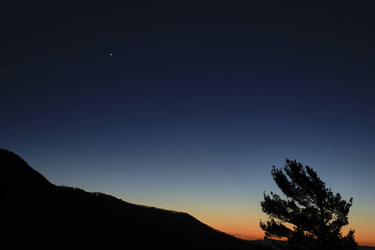 In this Sunday, Dec. 13, 2020 photo made available by NASA, Saturn, top, and Jupiter, below, are seen after sunset from Shenandoah National Park in Luray, Va. The two planets are drawing closer to each other in the sky as they head towards a “great conjunction” on Monday, Dec. 21, where the two giant planets will appear a tenth of a degree apart. (Bill Ingalls/NASA via AP)