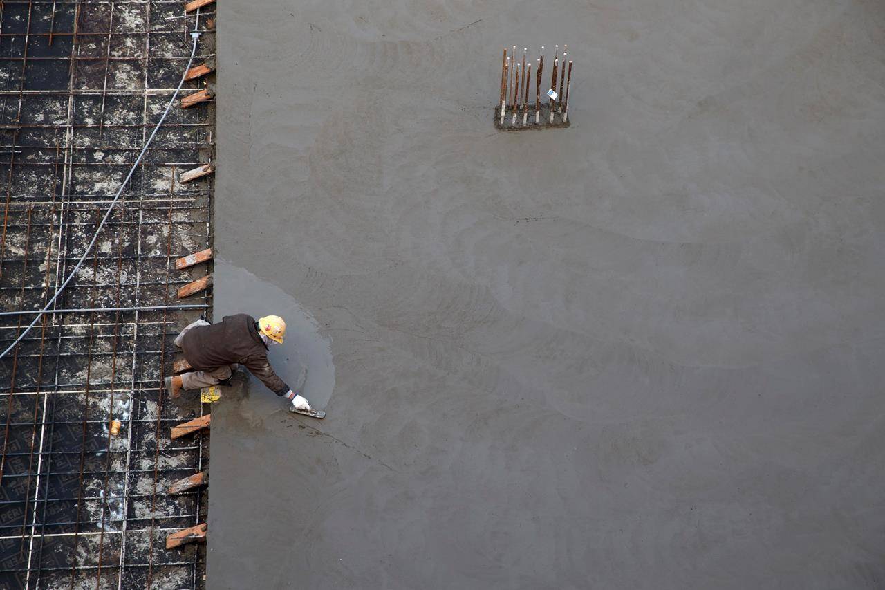 A worker smooths concrete at a residential housing construction site in Toronto, Thursday, Jan. 16, 2020. Consultants at BTY say construction activity could pick up next year in many provinces, amid anticipated spending on infrastructure and renewable energy.THE CANADIAN PRESS/Cole Burston