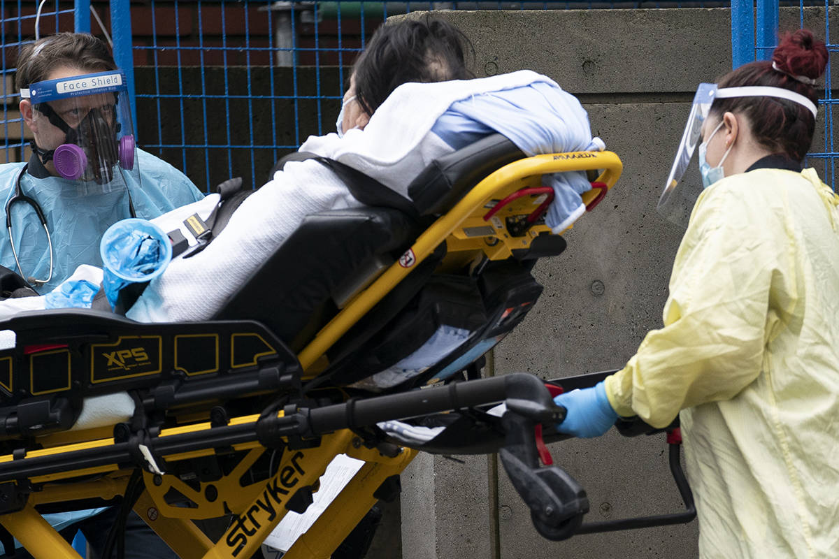 Medical personnel wear personal protective equipment to help prevent the spread of COVID-19 as they wheel a patient into St. Paul’s hospital in downtown Vancouver Monday, November 23, 2020. THE CANADIAN PRESS/Jonathan Hayward