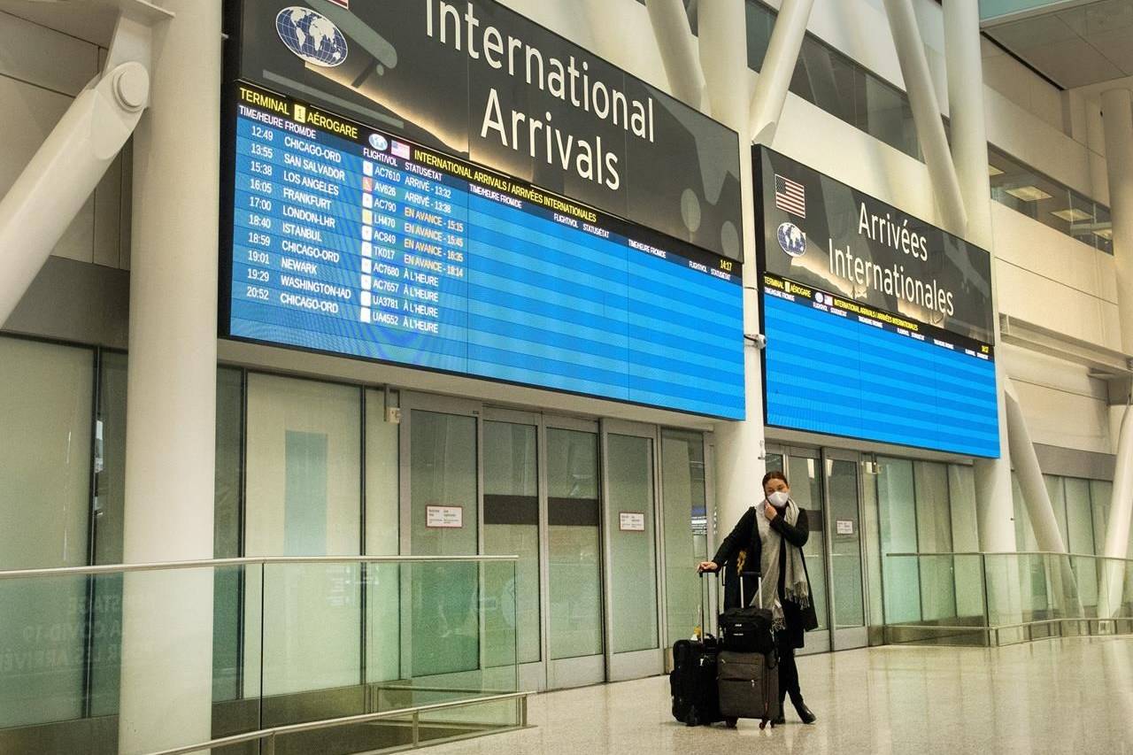 A lone passenger stands outside the International Arrivals area at Pearson Airport in Toronto on Tuesday, Jan. 26, 2021. As the federal government prepares to slap new restrictions on foreign arrivals, Health Canada data suggest a growing number of infections directly connected to international travel. THE CANADIAN PRESS/Frank Gunn
