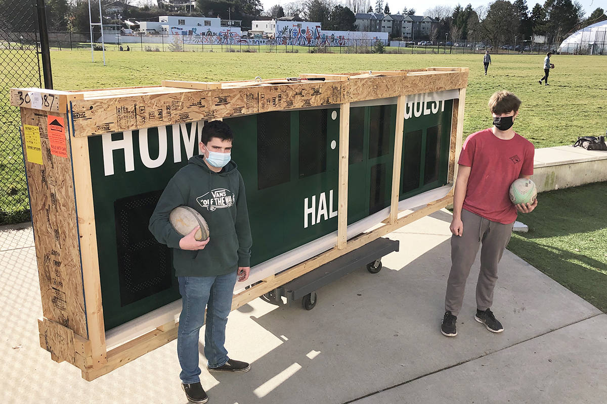 Oak Bay High Grade 10 students Oliver Wakely and Alex Joiner with the new scoreboard to soon be installed on the grass turf. Fundraising from the Oak Bay Barbarians rugby alumni and Oak Bay Fire Fighters Charitable Foundation. (Travis Paterson/News Staff)