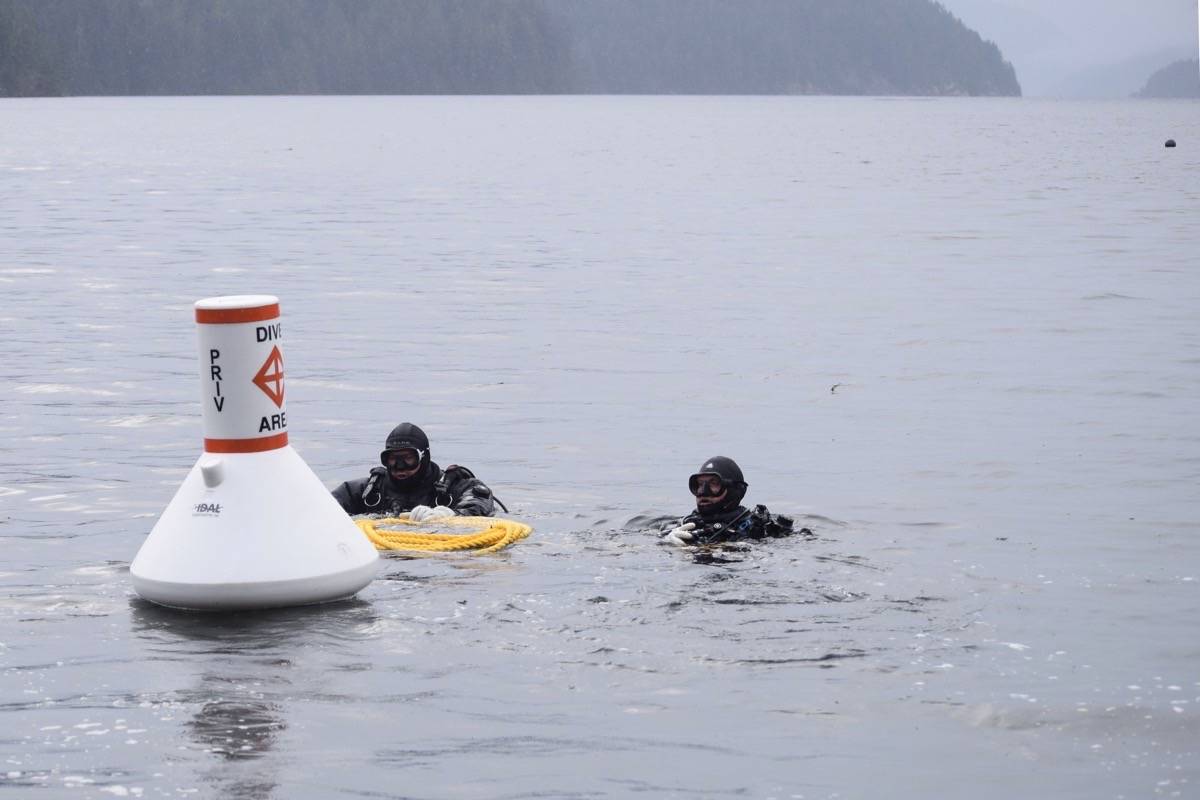 Tim Preston and Scott McFarlane carry the buoy out to the migrant wreck. In the top right corner of the photo is the temporary buoy that previously marked the dive site. (ELENA RARDON / ALBERNI VALLEY NEWS)