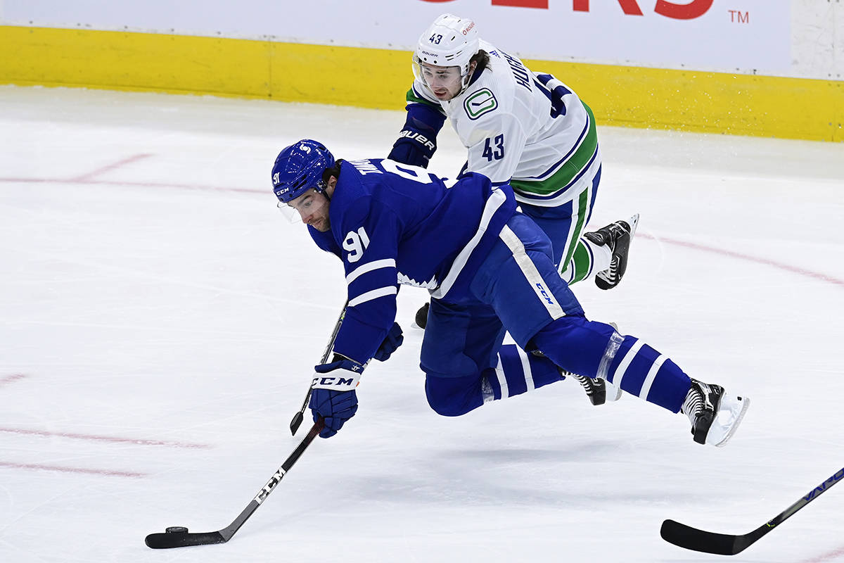 Vancouver Canucks defenceman Quinn Hughes (43) picks up a tripping penalty on Toronto Maple Leafs centre John Tavares (91) during first period NHL action in Toronto on Thursday, Feb. 4, 2021. THE CANADIAN PRESS/Frank Gunn