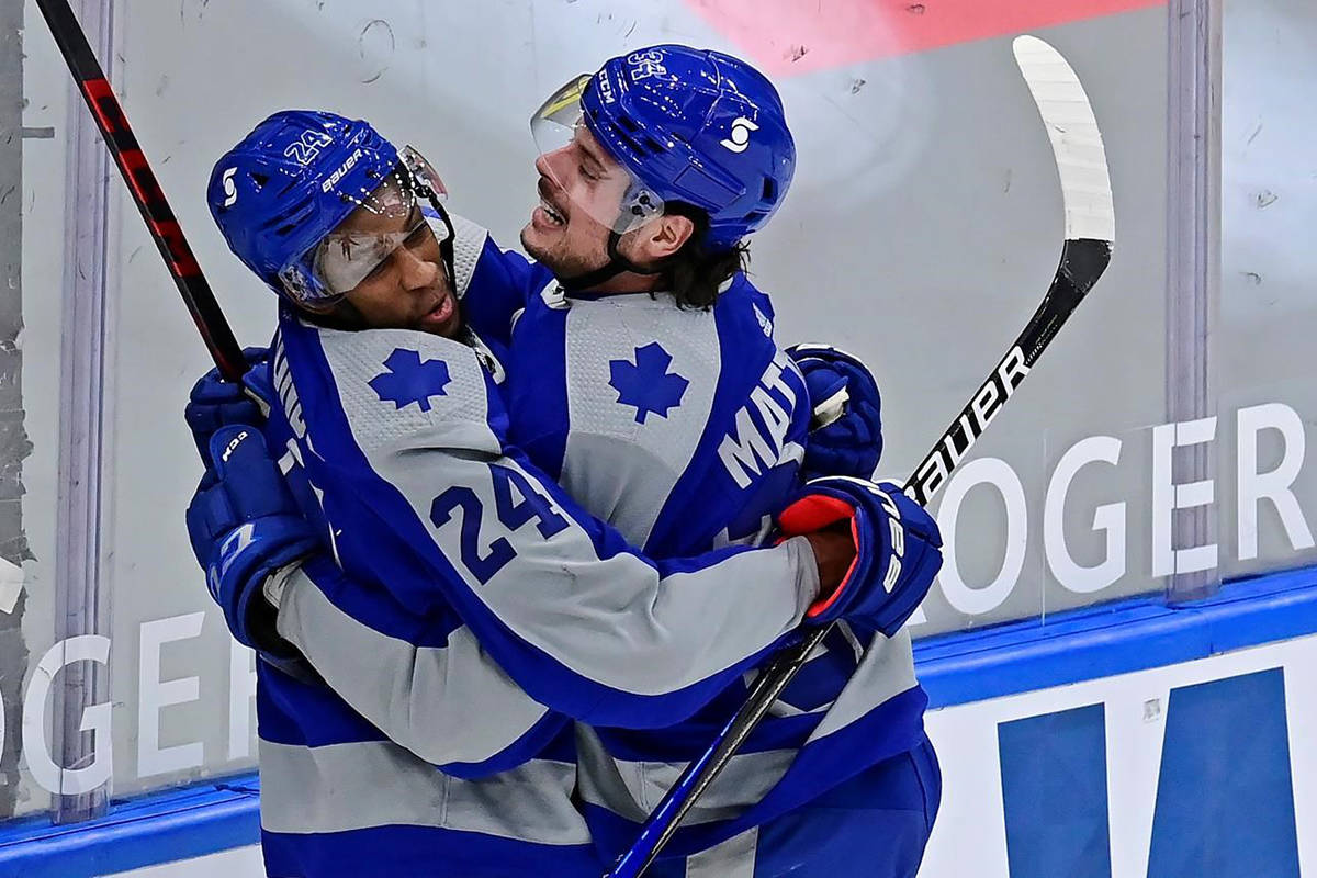 Toronto Maple Leafs right wing Wayne Simmonds (24) celebrates his goal against the Vancouver Canucks with teammate Auston Matthews (34) during first period NHL hockey action in Toronto on Saturday, February 6, 2021. THE CANADIAN PRESS/Frank Gunn