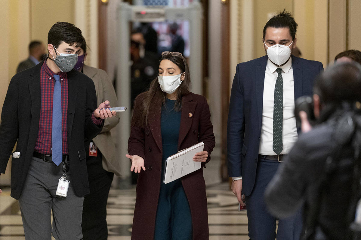 Rep. Alexandria Ocasio-Cortez, D-N.Y., leaves the House floor during a vote to remove Rep. Marjorie Taylor Greene, R-Ga., from committee assignments over her extremist views, on Capitol Hill in Washington, Thursday, Feb. 4, 2021. (AP Photo/Andrew Harnik)
