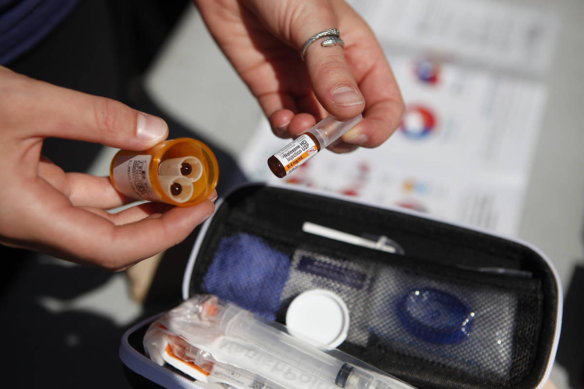 FILE – An organizer displays a naloxone kit that people can pick up for free as International Overdose Awareness Day training seminar takes place at Centennial Square in Victoria, B.C., on Saturday August 31, 2019. THE CANADIAN PRESS/Chad Hipolito
