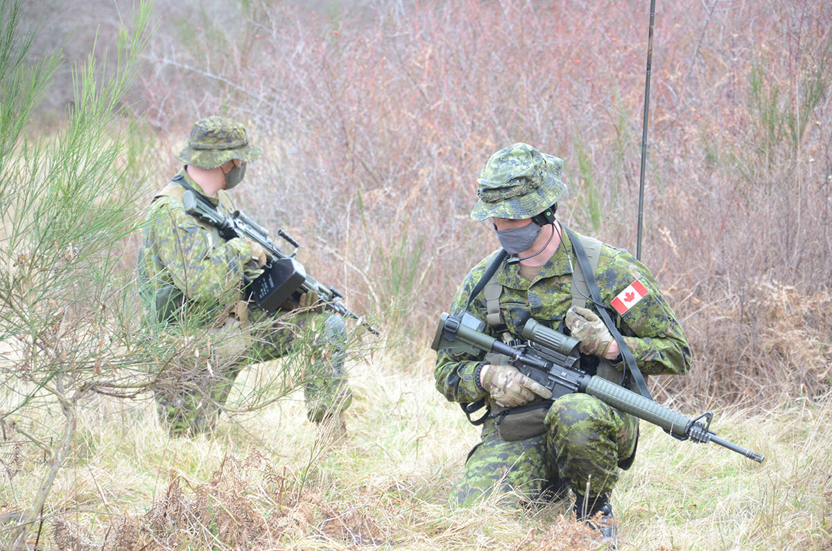 The soldiers practise with radios communicating during an exercise. Photo by Mike Chouinard