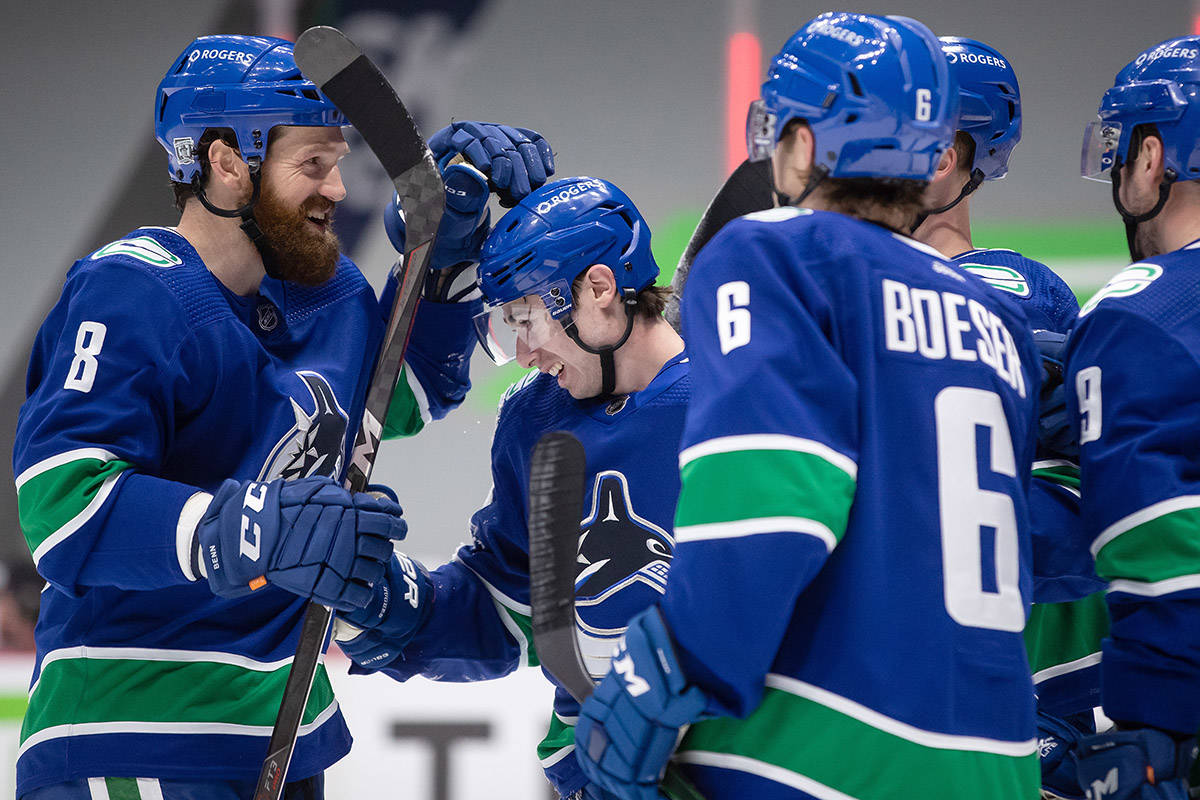 Vancouver Canucks’ Jordie Benn, from left to right, Quinn Hughes, Brock Boeser, Elias Pettersson, of Sweden, and J.T. Miller celebrate Hughes’ goal against the Calgary Flames during the second period of an NHL hockey game in Vancouver, on Saturday, Feb. 13, 2021. THE CANADIAN PRESS/Darryl Dyck