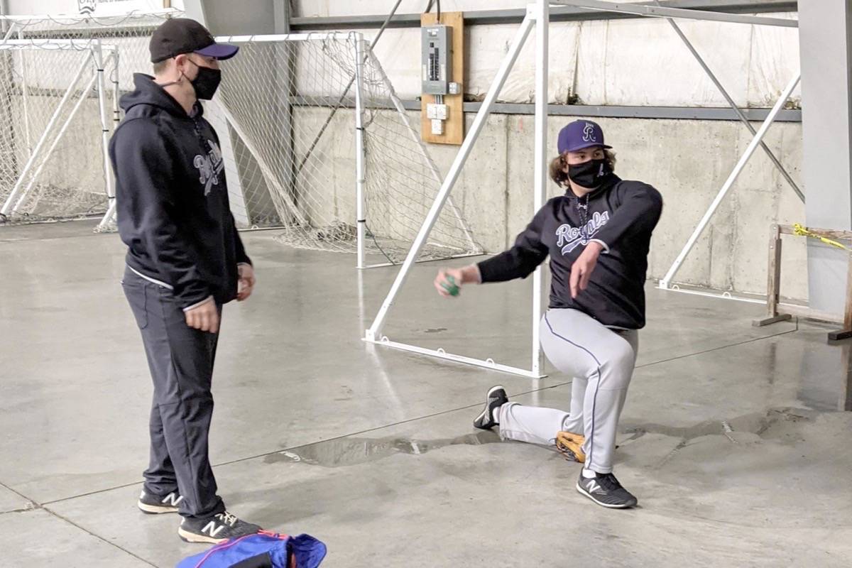 Breandan McLaughlin goes through a weighted ball workout under the watchful eye of coach Bruce Biro. (Parksville Royals photo)