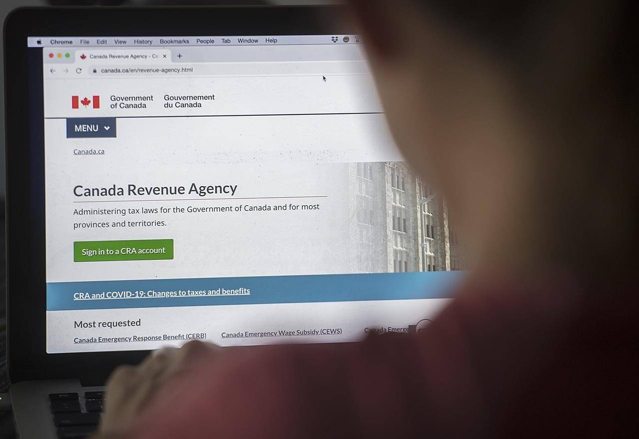 A person looks at a Canada Revenue Agency homepage in Montreal, Sunday, August 16, 2020. The Canada Revenue Agency says some taxpayers were locked out of their online accounts even though it wasn’t the victim of a cyberattack. THE CANADIAN PRESS/Graham Hughes