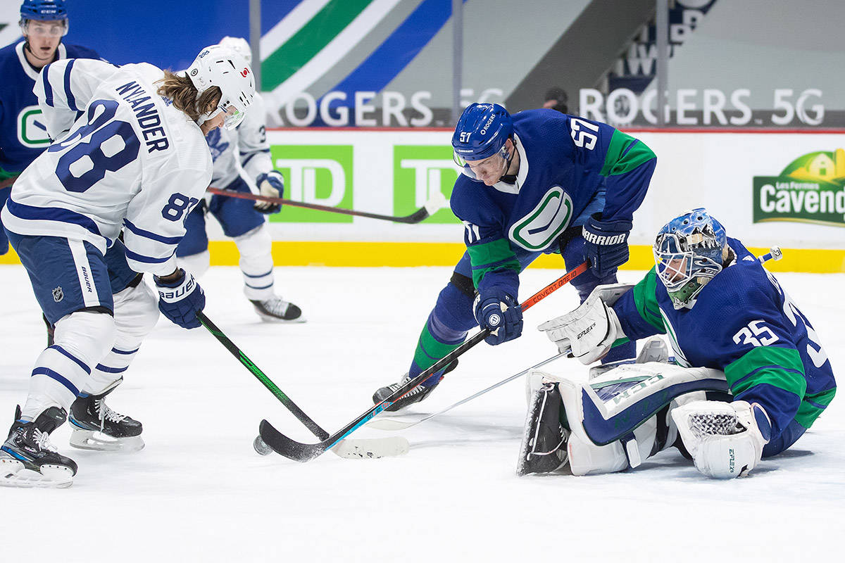 Toronto Maple Leafs’ William Nylander (88) is stopped by Vancouver Canucks’ Tyler Myers (57) and goalie Thatcher Demko (35) during the first period of an NHL hockey game in Vancouver, on Saturday, March 6, 2021. THE CANADIAN PRESS/Darryl Dyck