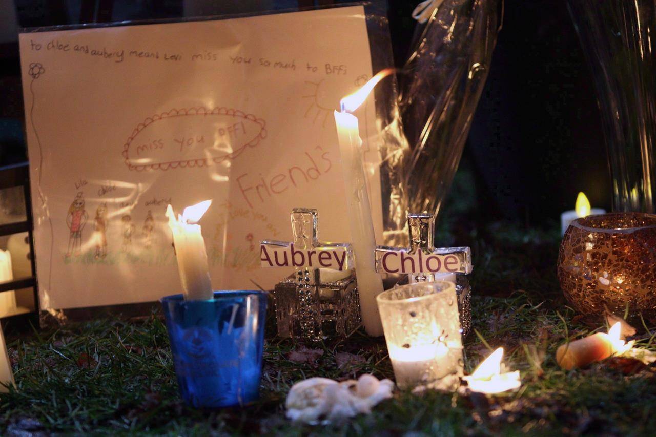 Pictures and notes in from friends and classmates make up a memorial in support and memory of Aubrey Berry, 4, and her sister Chloe, 6, during a vigil held at Willows Beach in Oak Bay, B.C., on December 30, 2017. THE CANADIAN PRESS/Chad Hipolito