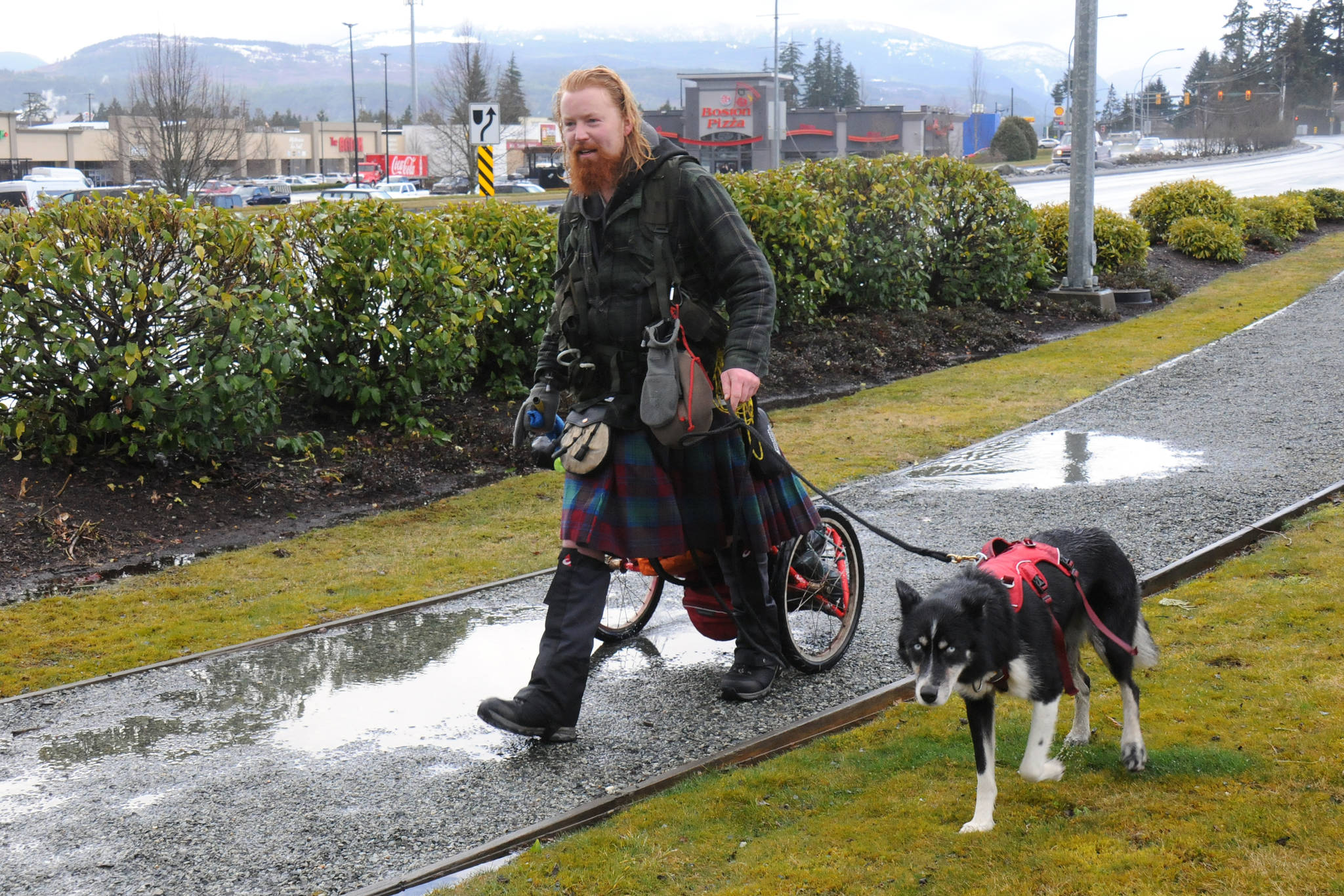 Michael Yellowlees and his dog Luna continue on their journey through Port Alberni after a couple of interviews on a soggy Friday, March 5, 2021. Yellowlees left Tofino four days previously and intends to walk to Newfoundland and Labrador to raise awareness for a Scottish environmental charity. (SUSAN QUINN/ Alberni Valley News)