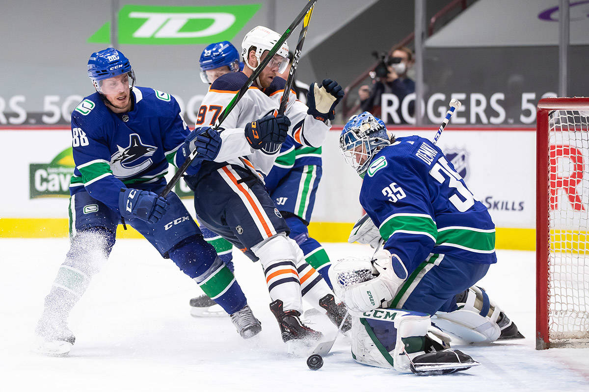 Vancouver Canucks goalie Thatcher Demko (35) stops Edmonton Oilers’ Connor McDavid (97) as Vancouver’s Nate Schmidt (88) defends during the first period of an NHL hockey game in Vancouver, on Saturday, March 13, 2021. THE CANADIAN PRESS/Darryl Dyck