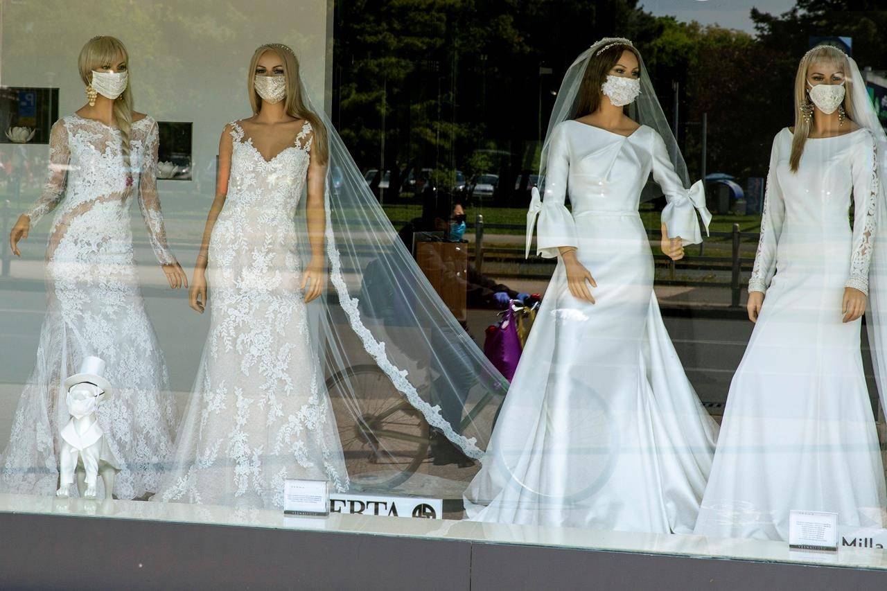The window of a wedding dress store with mannequins wearing face masks on Thursday, April 23, 2020. The store is closed because of COVID-19 lockdown. THE CANADIAN PRESS/AP-Darko Bandic