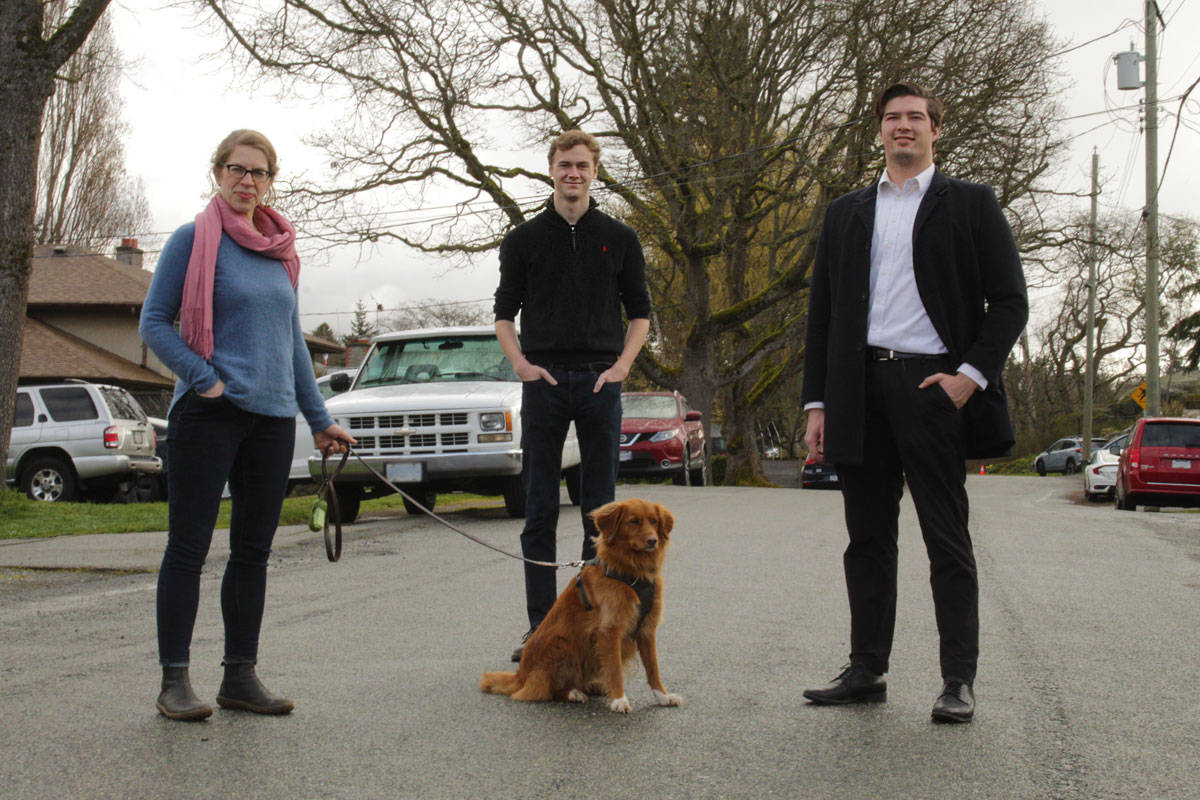 Couns. Rebecca Mersereau (left), Ned Taylor and Zac de Vries visit Leslie Drive in Saanich – a residential road with no centreline or sidewalk – on March 20 with pup Piper. They feel streets like these should have a speed limit of 30 km/h. (Devon Bidal/News Staff)