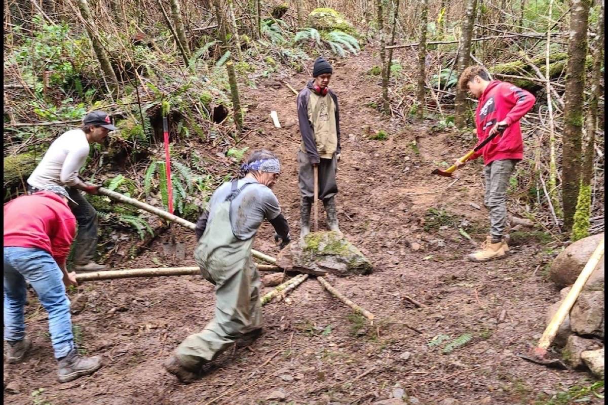 Ucluelet Mountain Bike Association volunteers and Ucluelet First Nation youth work on a mountain bike trail in Ucluelet First Nations territory. (UMBA photo)