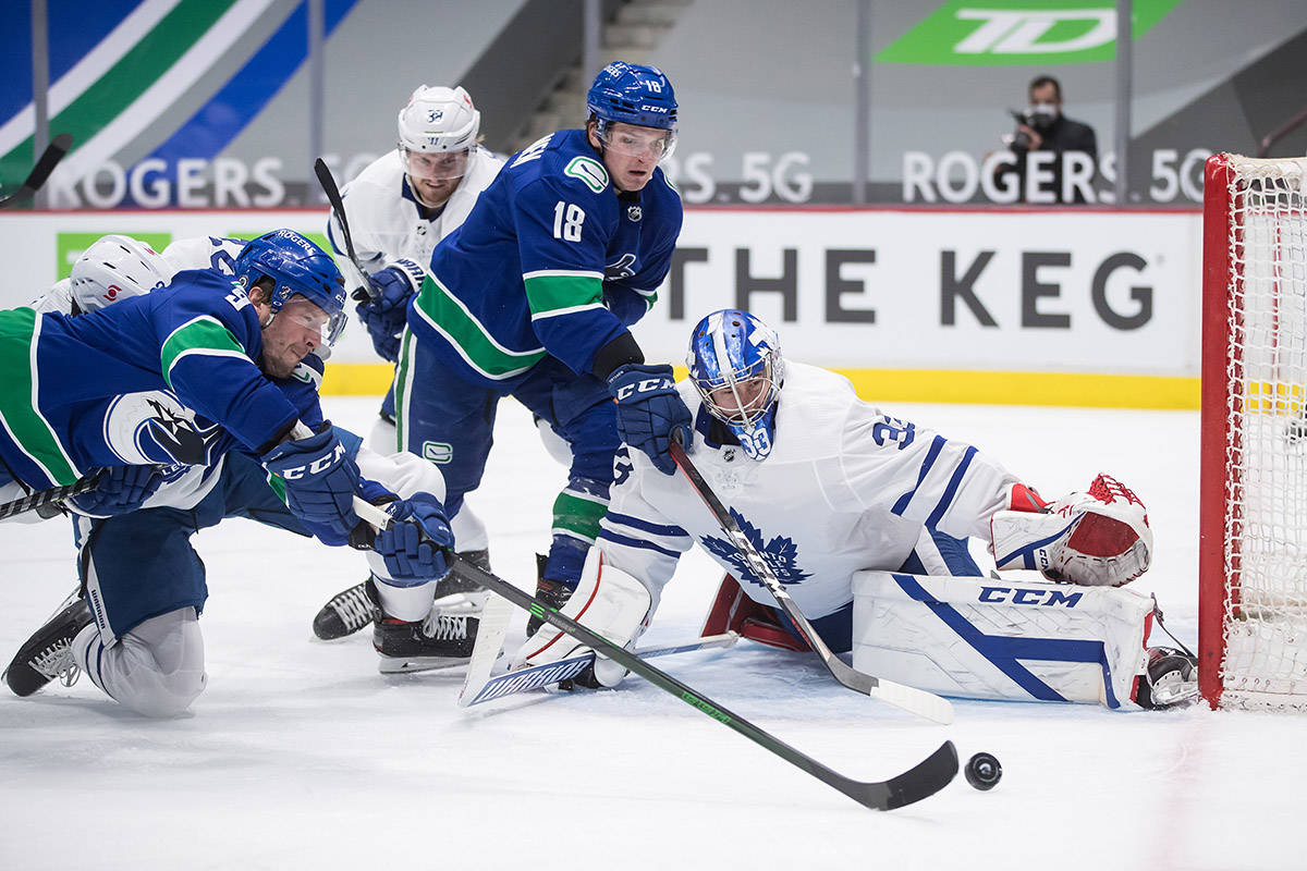 Vancouver Canucks’ J.T. Miller, front left, puts a shot wide of the goal behind Toronto Maple Leafs goalie David Rittich (33), of the Czech Republic, as Vancouver’s Jake Virtanen (18) watches during the second period of an NHL hockey game in Vancouver, on Tuesday, April 20, 2021. THE CANADIAN PRESS/Darryl Dyck
