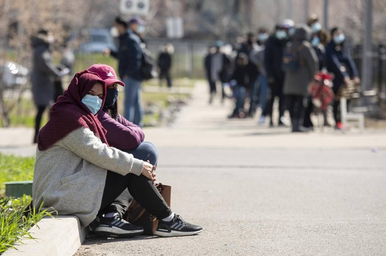 Two women take a break from the line-up at a mobile COVID19 vaccine clinic at Parkway Forest Community Centre in Toronto on Monday, April 19, 2021.THE CANADIAN PRESS/Frank Gunn