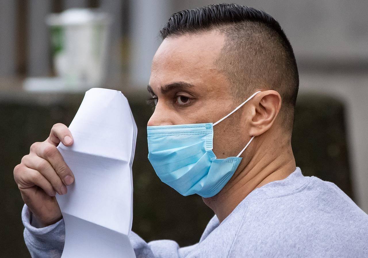 Mohammad Movassaghi and a copy of his release order as he leaves Vancouver Police Department jail. THE CANADIAN PRESS/Darryl Dyck