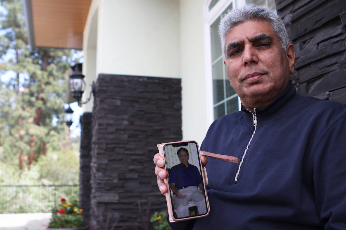 Ashok Mohan holds up a photo of his brother-in-law, Vijay Sharma, who died from complications due to COVID-19 on April 27, 2021. A 72-year-old retired bank manager, Sharma had been living in the city of Jabalpur, India when he was infected and died within 10 days of contracting the virus. (Aaron Hemens/Capital News)