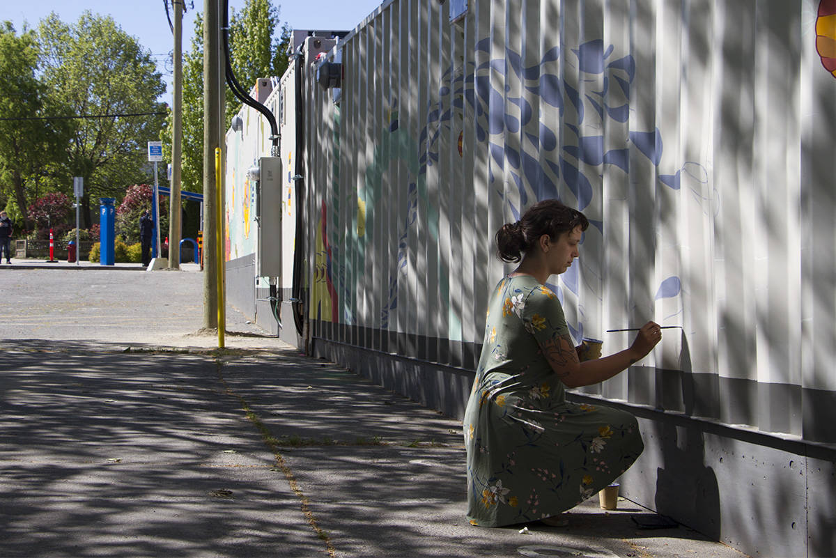 Kay Gallivan paints a mural on the east wall of North Park’s Tiny Home Village (Kiernan Green / Victoria News Staff)