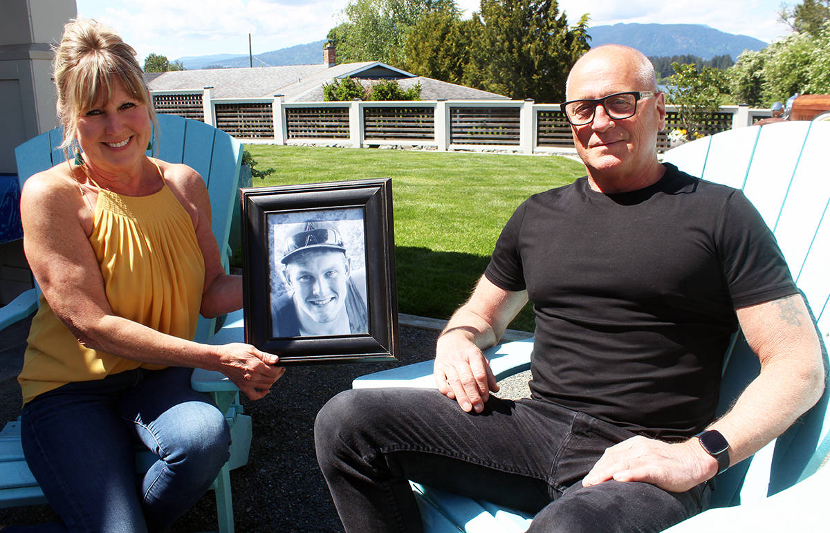 Brenda and Steve Smith with a photo of Derek Descoteau. It’s been five years since Derek was murdered in Chemainus. (Photo by Don Bodger)