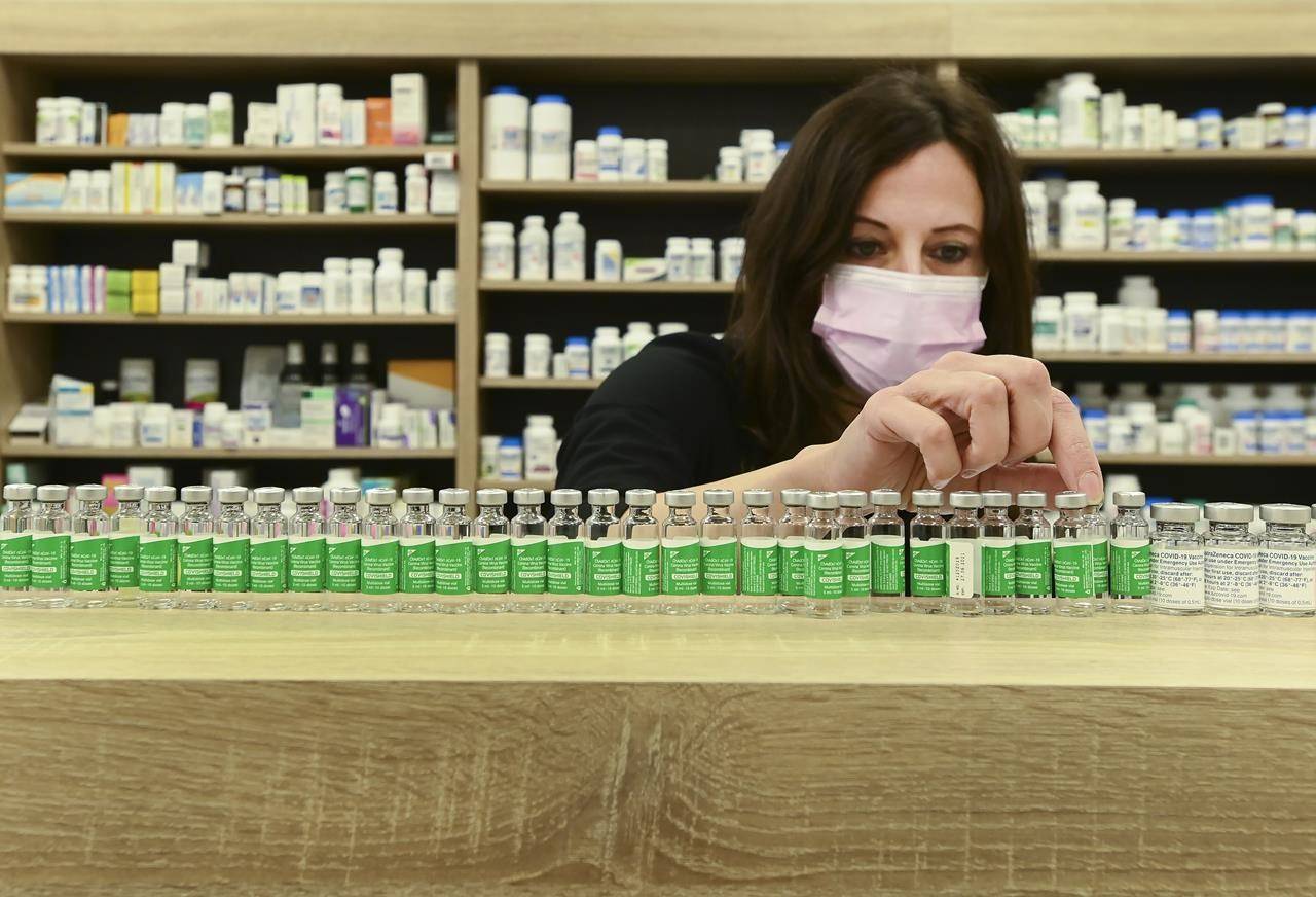Pharmacist Barbara Violo arranges all the empty vials of the Oxford-AstraZeneca COVID-19 vaccines at the Junction Chemist during the COVID-19 pandemic in Toronto, on Monday, April 19, 2021. THE CANADIAN PRESS/Nathan Denette