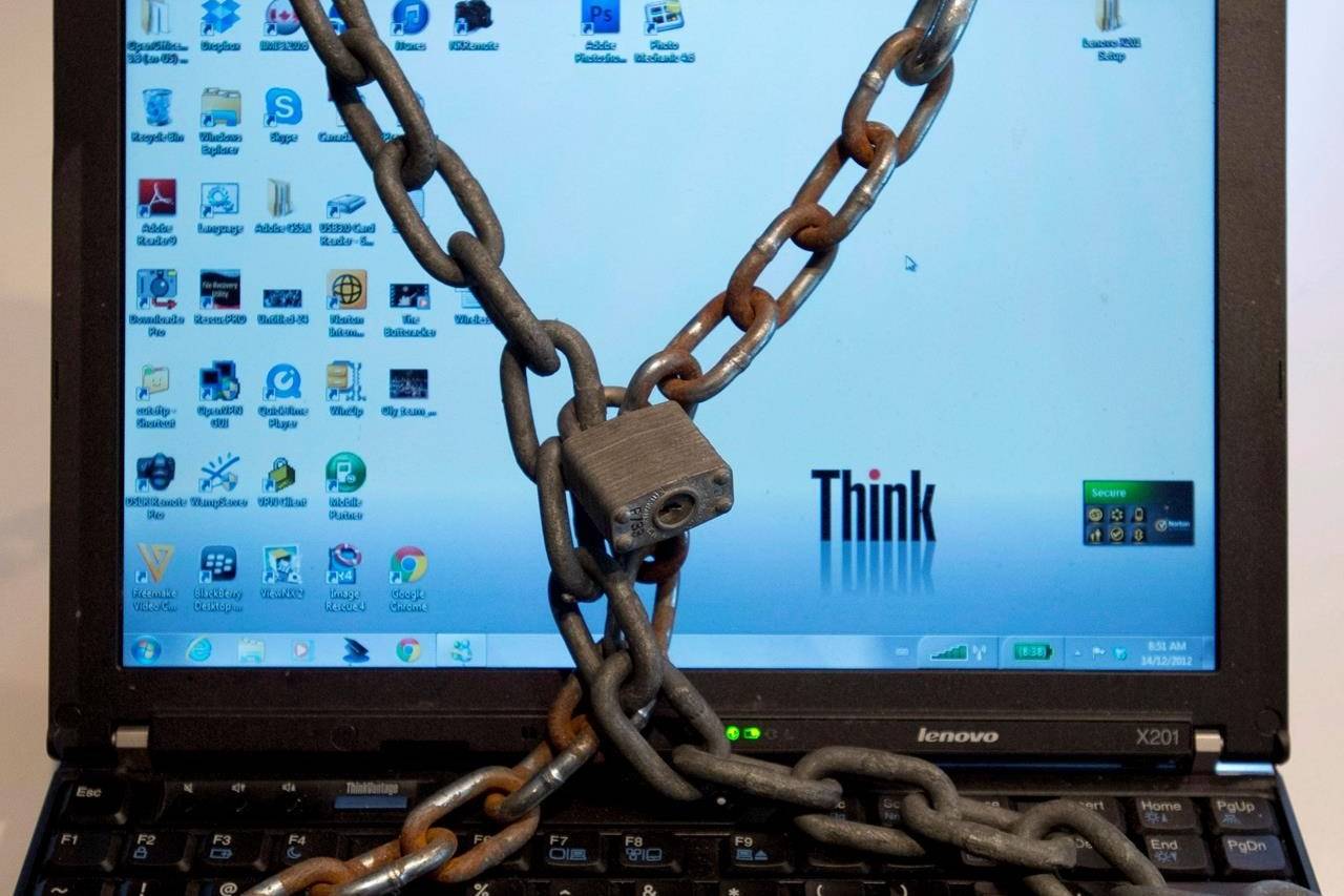 A computer wrapped in padlocked chains is seen in Montreal in a Dec. 14, 2012, photo illustration. The sort of brazen digital attack that recently shut down a key U.S. energy pipeline could strike Canada, says the head of the federal cyberprotection agency. THE CANADIAN PRESS/Ryan Remiorz