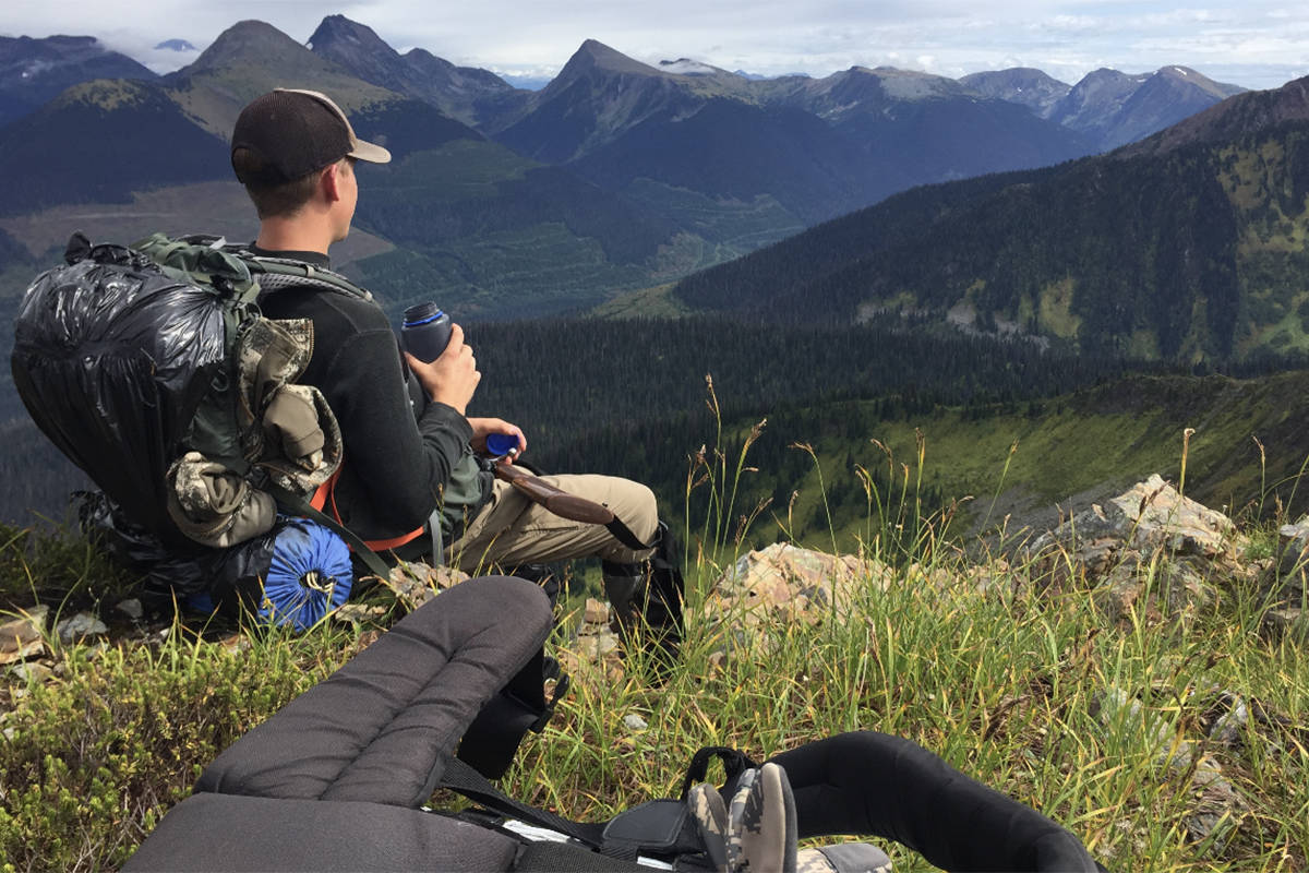 Sam Fait takes a break to enjoy the view from the mountains east of Williams Lake. (Williams Lake Tribune photo)