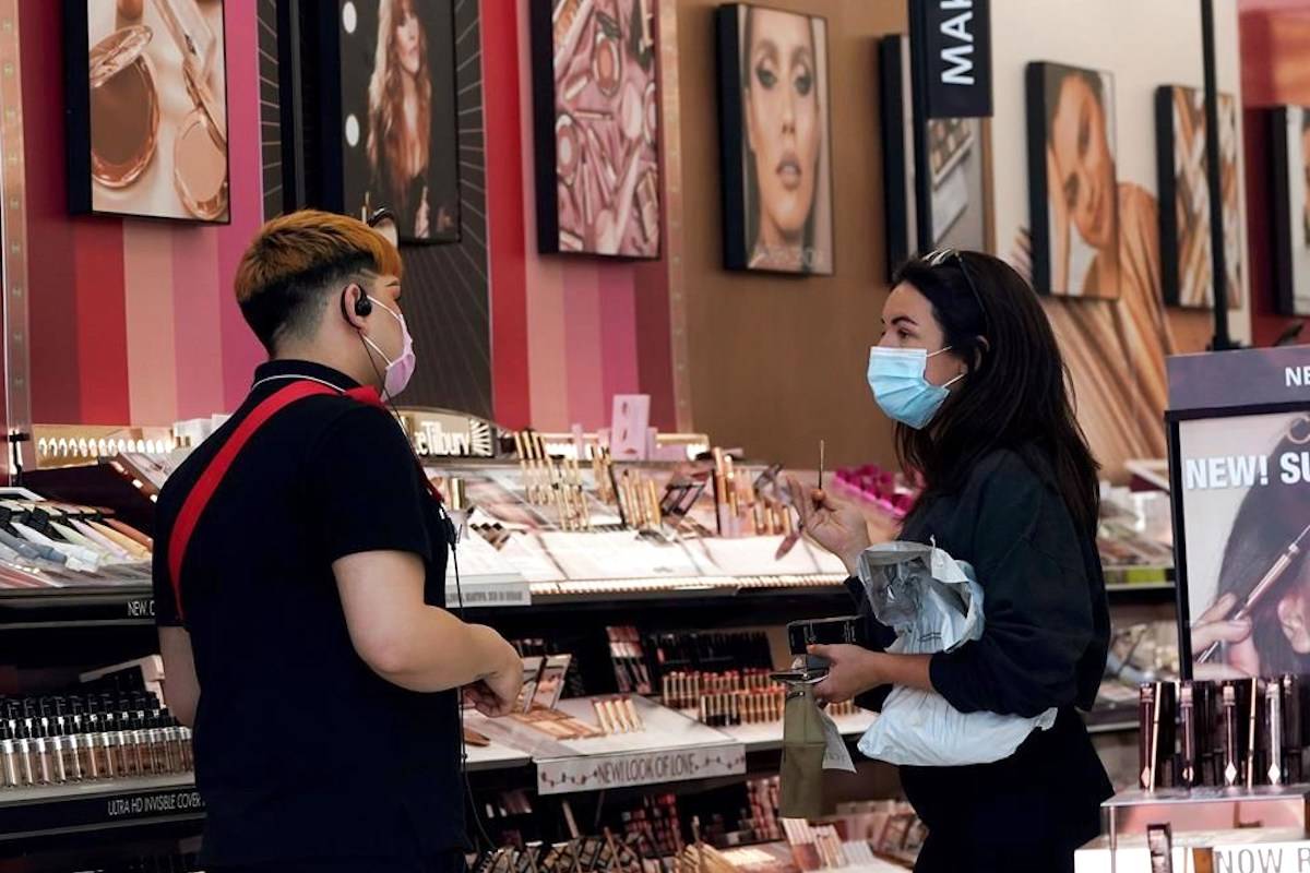 A worker, at left, tends to a customer at a cosmetics shop amid the COVID-19 pandemic Thursday, May 20, 2021, in Los Angeles. (AP Photo/Marcio Jose Sanchez)