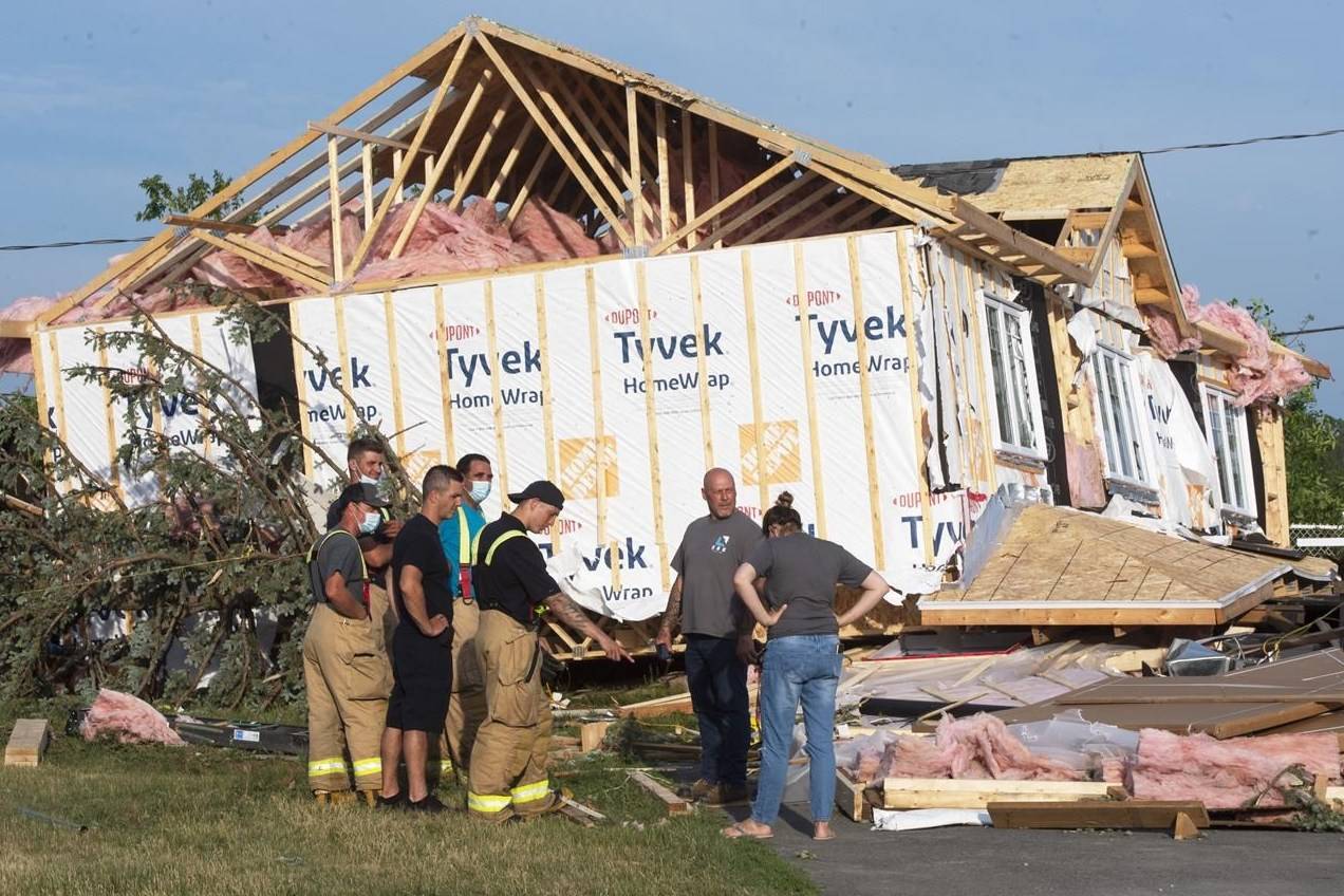 People look over the damage after a tornado touched down in Mascouche, Que., north of Montreal, Monday, June 21, 2021. Dozens of homes were damaged and one death has been confirmed. THE CANADIAN PRESS/Ryan Remiorz