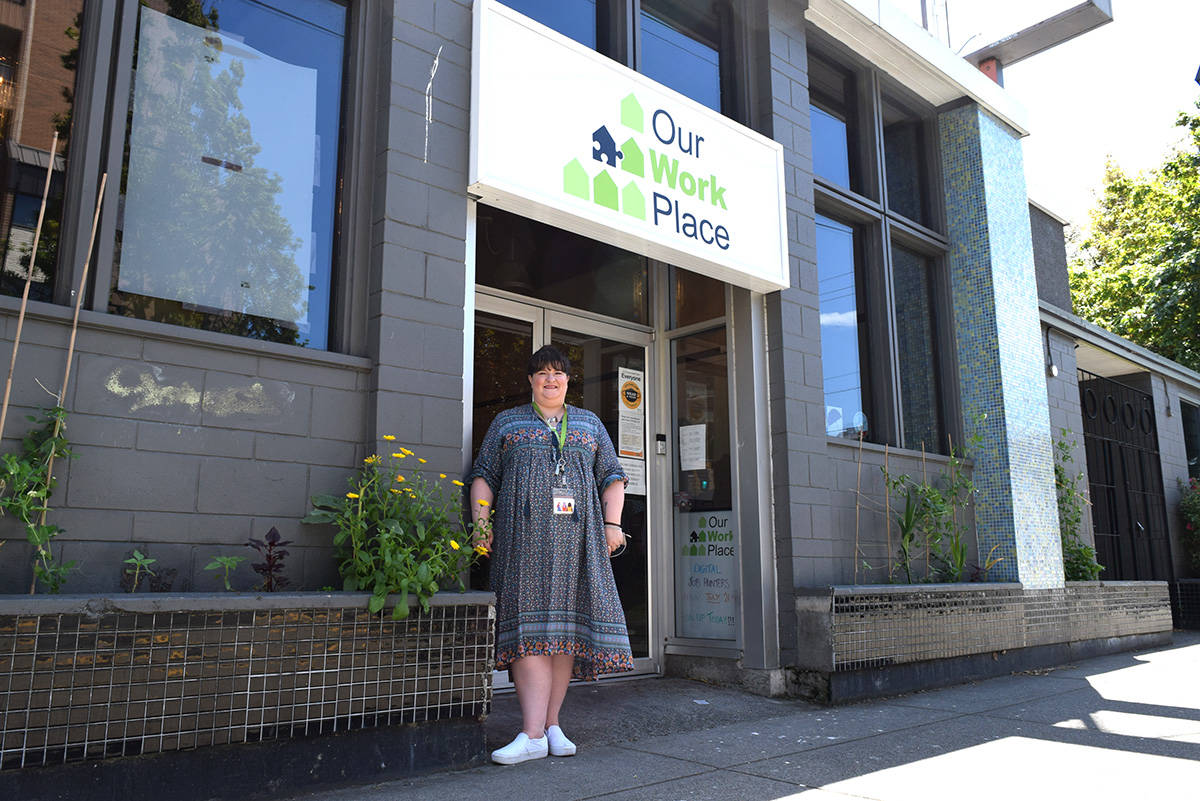 Ashley MacDonald, Our WorkPlace manager, outside their offices newly revealed facade featuring their new name. (Kiernan Green / Victoria News Staff)