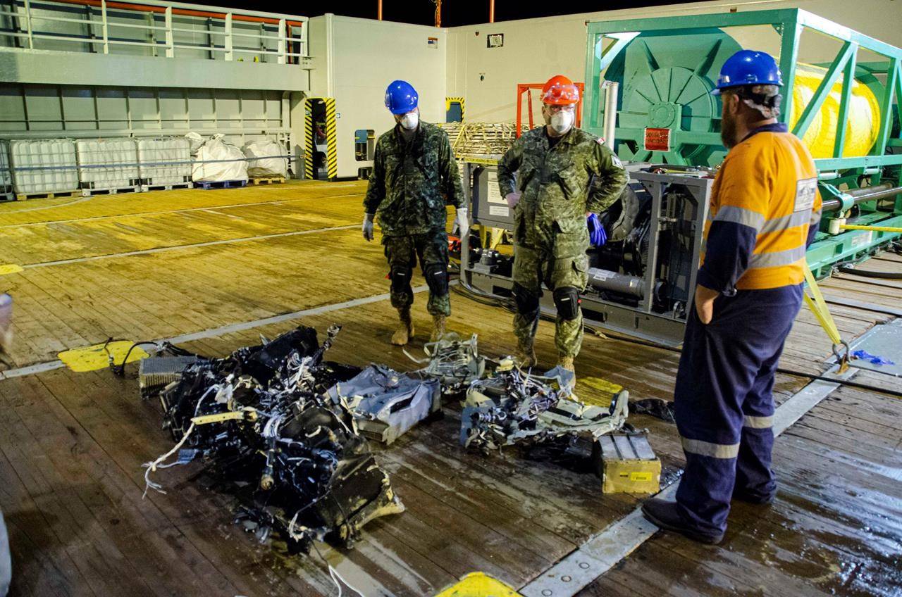 Canadian Forces members and EDT Hercules personnel inspect recovered parts of the helicopter Stalker 22 during recovery operations for the aircraft in the Mediterranean Sea on May 31, 2020. THE CANADIAN PRESS/HO-Department of National Defence, Cdr Robert Watt