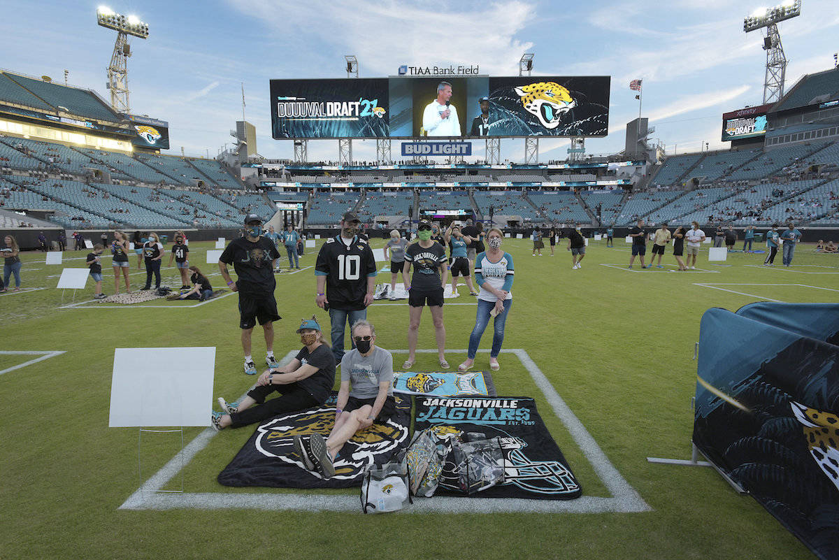 Socially distanced fans on the field and in the stands listen as coach Urban Meyer speaks during an NFL football draft party Thursday, April 29, 2021, in Jacksonville, Fla. (Bob Self/The Florida Times-Union via AP)