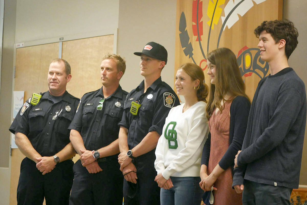 Oak Bay Four Pillars of Excellence Award recipients Anna Friesen (middle left), Orla Scott, and Jasper Calder, with members of the Oak Bay Fire Department during the Oak Bay High awards ceremony in June. (Evert Lindquist/News Staff)