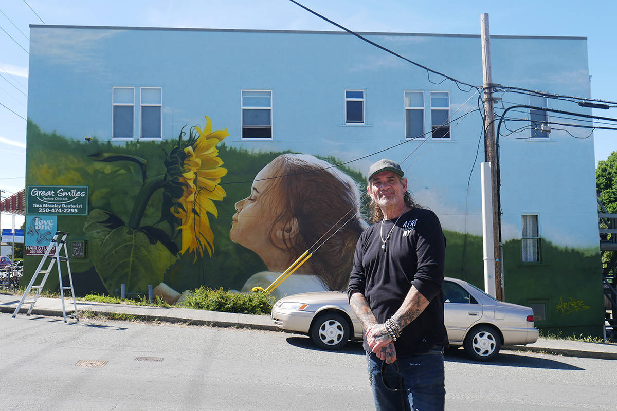 Airbrush artist Paul Archer stands before his newest mural in Victoria on Burnside Road, a project that took him only seven days. Archer estimates himself to have completed roughly 15,000 works of art, most of which are murals of various sizes. (Evert Lindquist/News Staff)