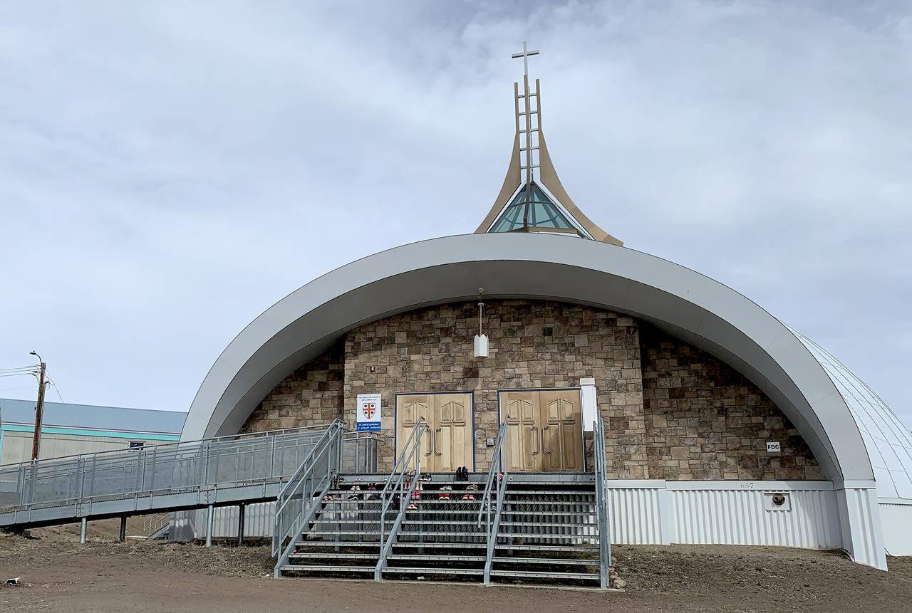 A few dozen children’s shoes have been placed on the steps of St. Jude’s Anglican Cathedral in Iqaluit, Friday, June 25, 2021. The mayor of Iqaluit says he will no longer bring forward a motion to make the city’s churches to pay taxes on land use. THE CANADIAN PRESS/Emma Tranter