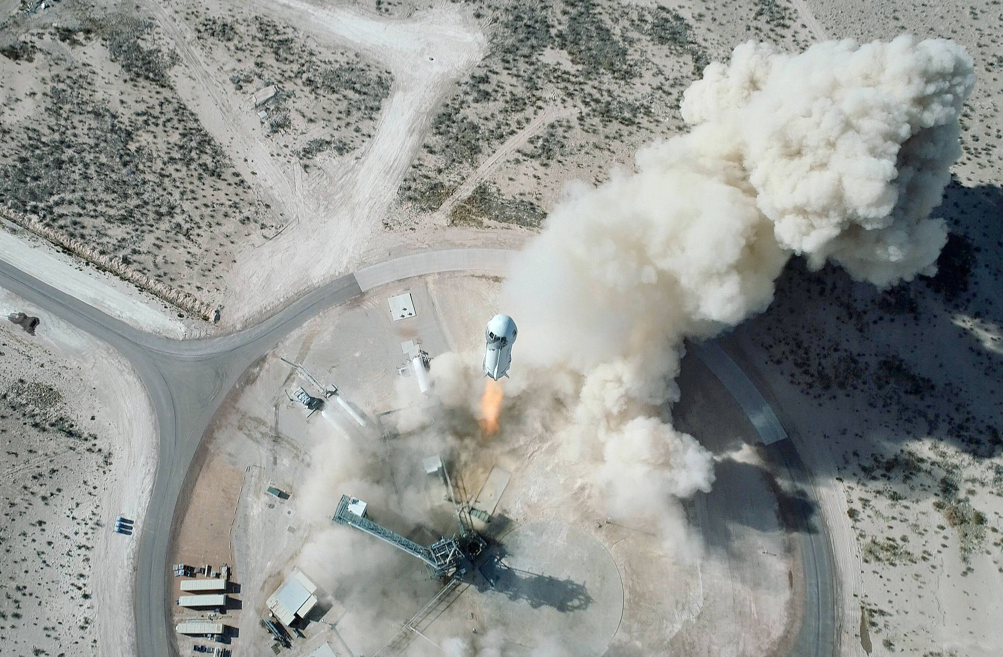 In this Jan. 14, 2021 photo made available by Blue Origin, the New Shepard NS-14 rocket lifts off from Launch Site One in West Texas. On Tuesday, July 20, 2021, Blue Origin’s 60-foot (18-meter) New Shepard rocket will accelerate toward space at three times the speed of sound, or Mach 3, before separating from the capsule and returning for an upright landing. (Blue Origin via AP)