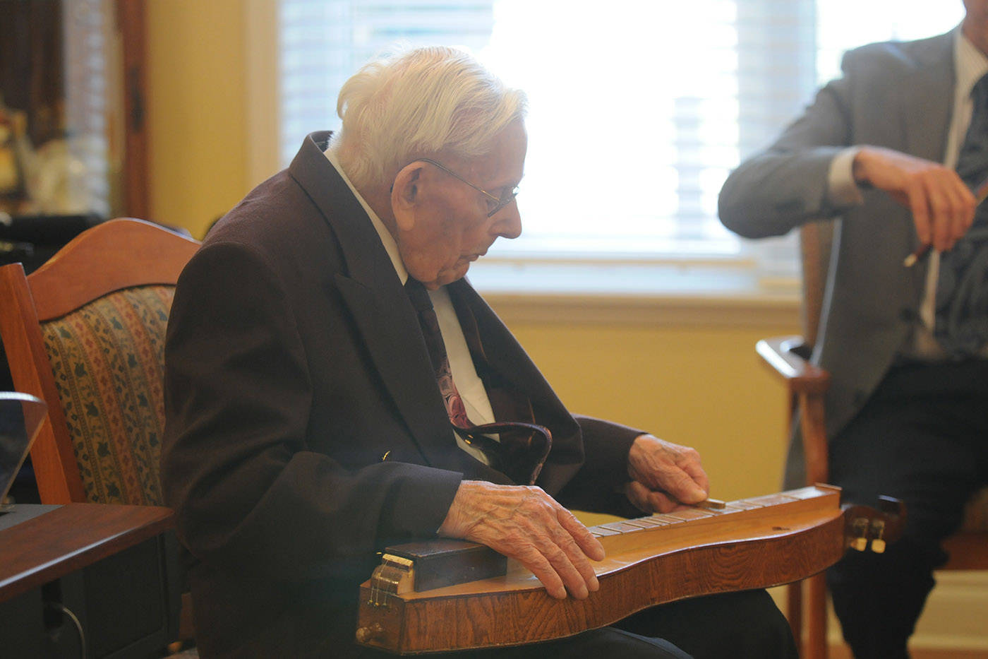George Braun entertains his birthday guests while playing his handmade Appalachian dulcimer on his 102 birthday at Cascade Manor in Chilliwack on March 28, 2013. Saturday, July 31, 2021 is Uncommon Instrument Awareness Day. (Jenna Hauck/ Chilliwack Progress file)