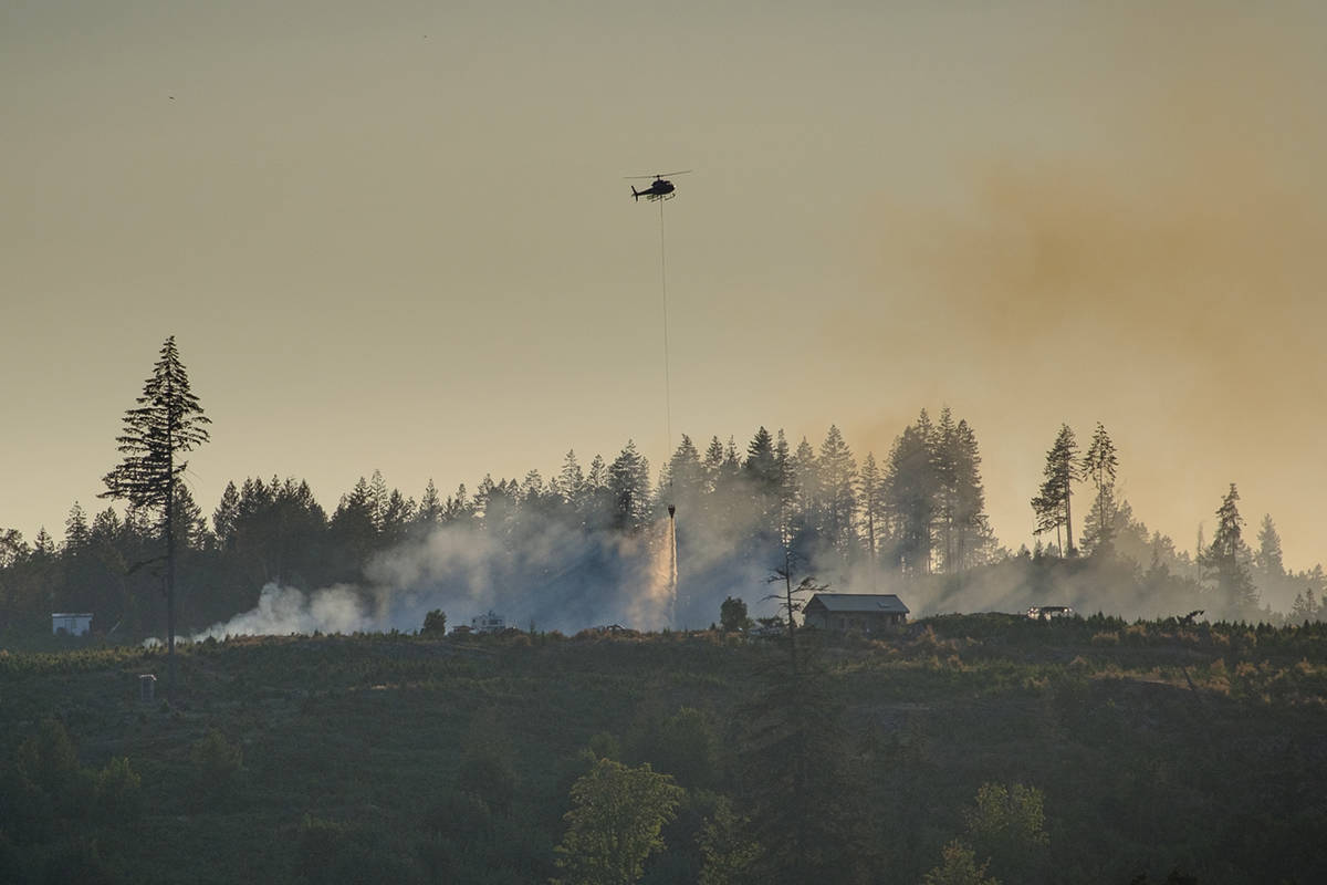 A helicopter drops water on a fire at Gogo’s Christmas Tree Farm on Monday, July 26. (Photo courtesy Brian Irwin)