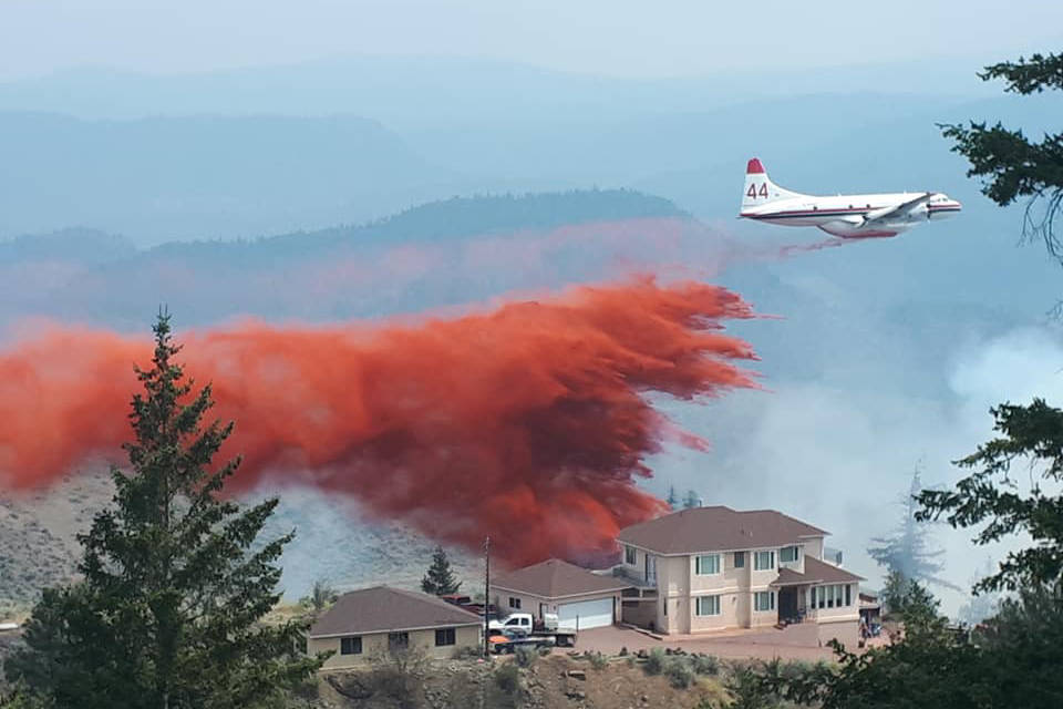 Air bombers drop fire retardant with precise accuracy to protect a home dangerously close to the Osoyoos wildfire that started up off Highway 3 Monday morning, July 5, 2021. (Sam Tibbitt photo Facebook)