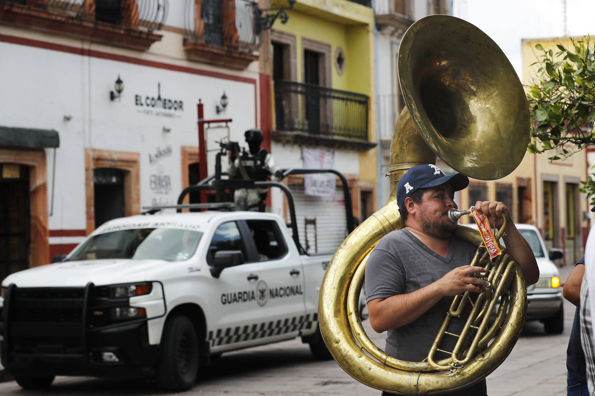A man plays the tuba as the National Guard patrols downtown Jerez, Zacatecas state, Mexico, Friday, July 16, 2021. For years, much of Mexico’s violence was focused along its northern border in cities like Tijuana, Ciudad Juarez and Nuevo Laredo. Now Zacatecas, including in the state capital of the same name, awaken everyday to the violence. (AP Photo/Marco Ugarte)