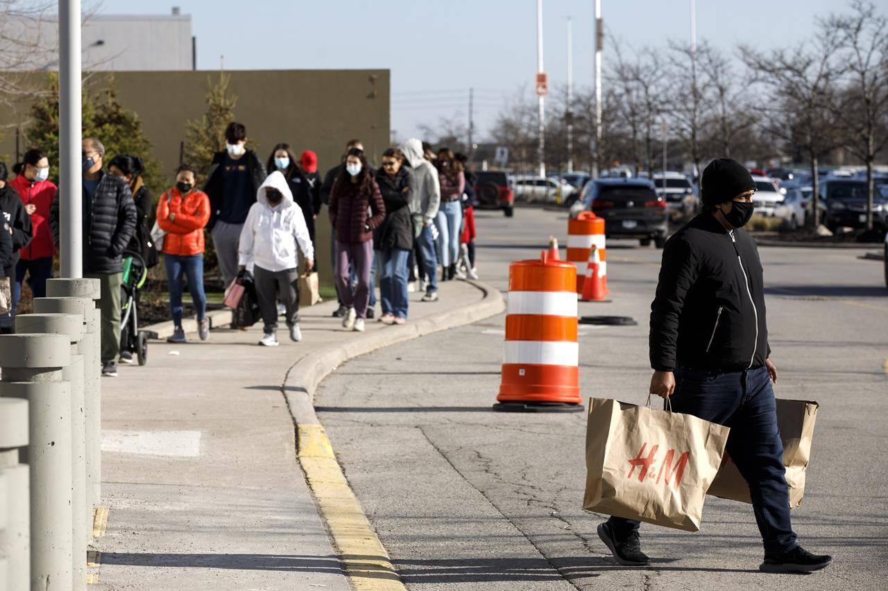 A shopper carries shopping bags as they leave Vaughan Mills Shopping Centre in Vaughan, Ont., on Sunday, Nov. 29, 2020. A survey commissioned by the co-working space company IWG found that 40 per cent of people believe the days of formal attire in the office are over, and 59 per cent think it’ll be acceptable to dress less formally in the office when they return. THE CANADIAN PRESS/Cole Burston