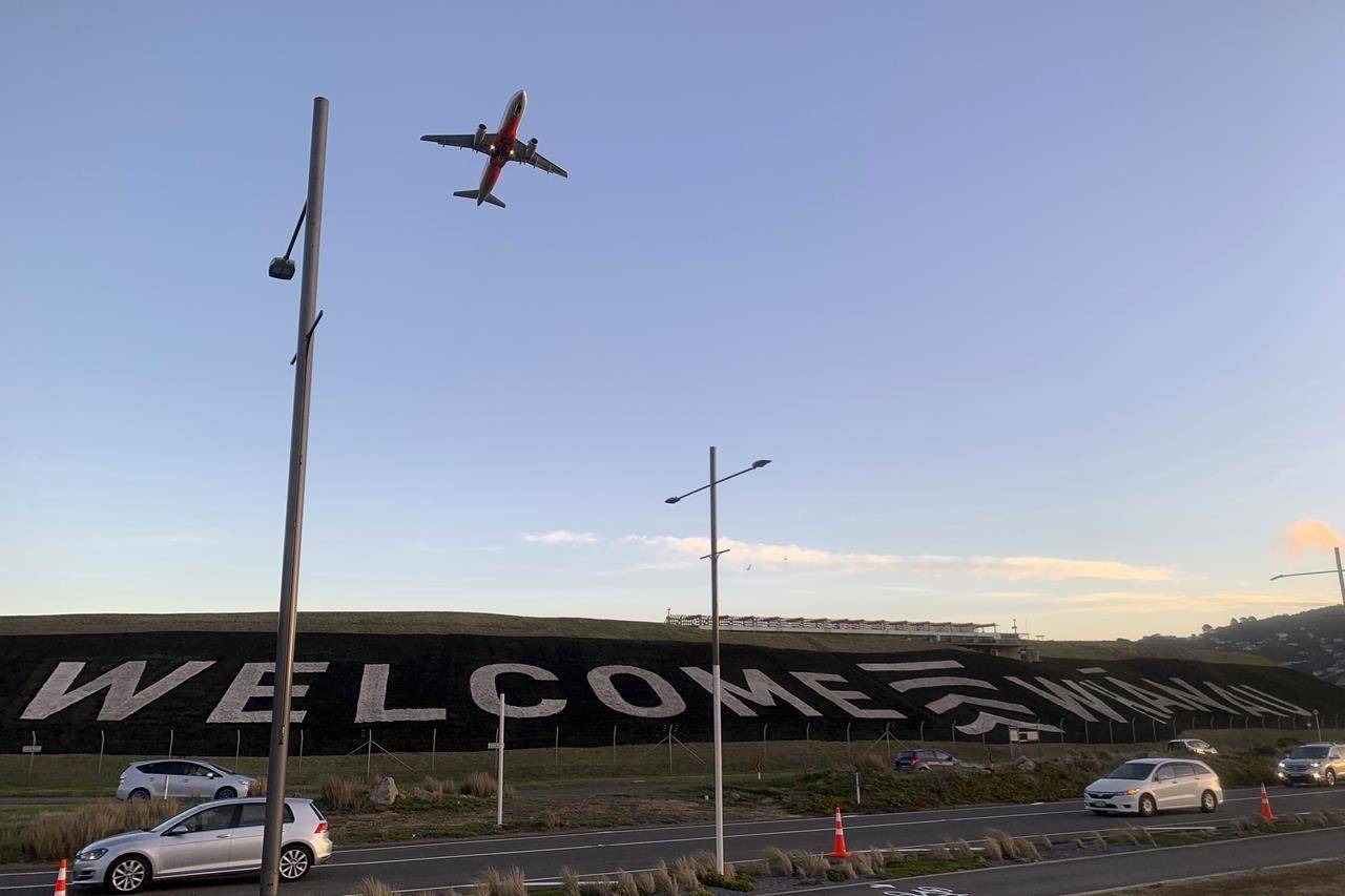 FILE - In this April 19, 2021, file photo, a giant sign painted near the main runway of the Wellington International Airport greets travelers returning home in Wellington, New Zealand. An expert group advising the government believes it is realistic for the country to maintain its zero-tolerance approach, which has included strict lockdowns for even small outbreaks, once it begins to reopen its borders. (AP Photo/Nick Perry, File)
