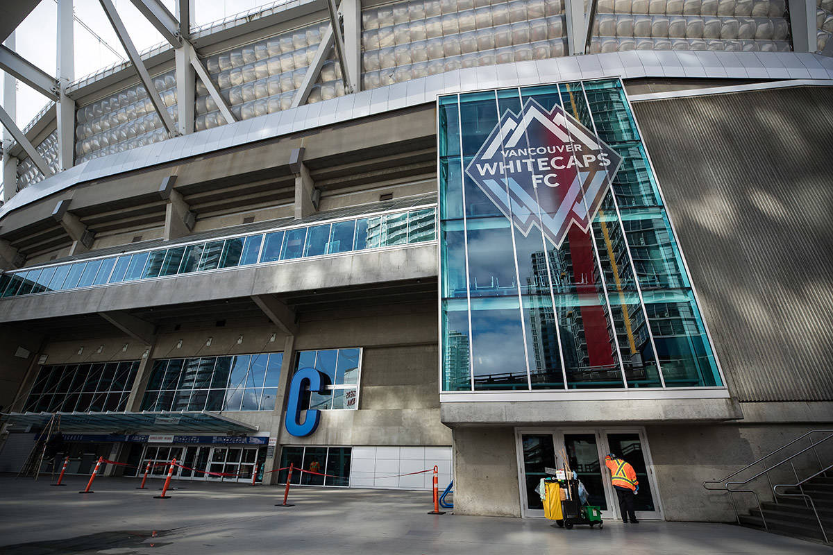 FILE – A worker cleans a door handle at B.C. Place stadium, where Major League Soccer’s Vancouver Whitecaps play their home games, in Vancouver, on Thursday, March 12, 2020. THE CANADIAN PRESS/Darryl Dyck