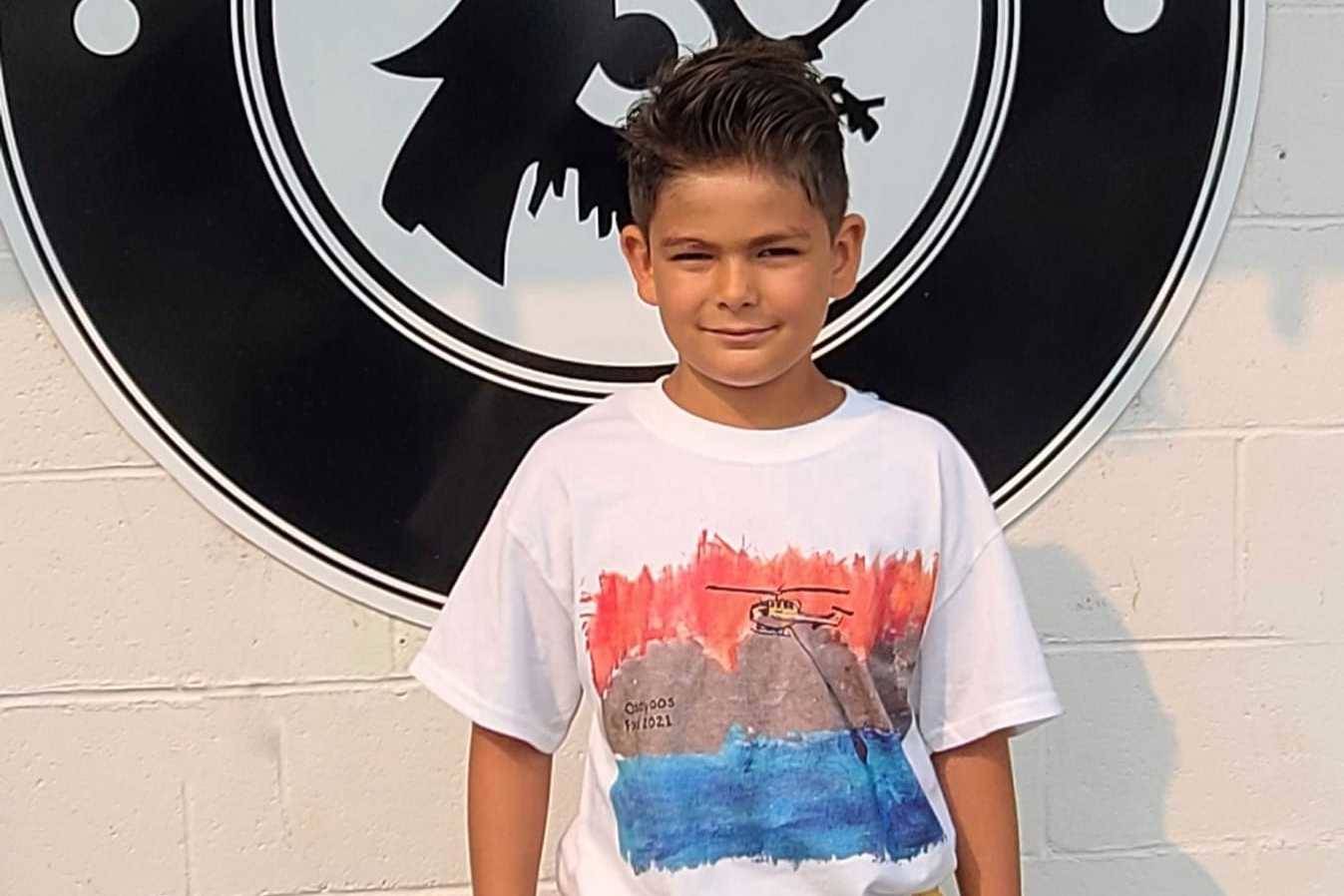 Ayden McKillop in the shirt he designed in support of the Osoyoos fire department (Junction 3 Coffeehouse/Facebook)