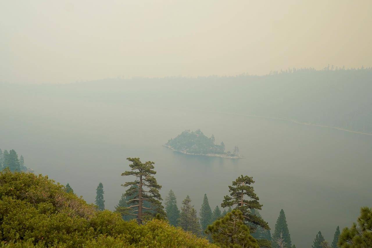 Lake Tahoe’s Emerald Bay is shrouded in smoke from the Caldor Fire, near South Lake Tahoe, Calif., Tuesday, Aug. 24, 2021. The massive wildfire, that is over a week old, has scorched more than 190 square miles, (492 square kilometers) and destroyed hundreds of homes since Aug. 14. It is now less than 20 miles from Lake Tahoe. (AP Photo/Rich Pedroncelli)