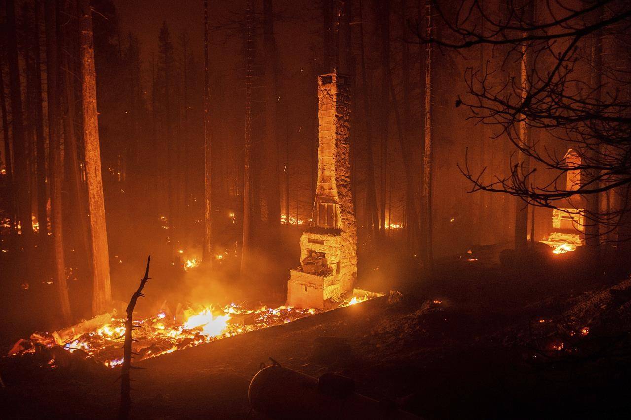 Seen in a long camera exposure, chimneys stand at residences leveled by the Caldor Fire along Highway 50 on Sunday, Aug. 29, 2021, in Eldorado National Forest, Calif. (AP Photo/Noah Berger)
