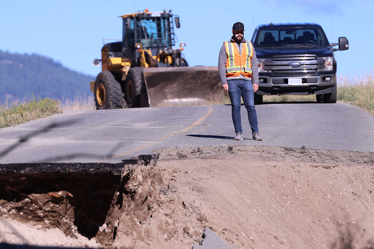 Greg McNeil, operations manager at Yellowhead Road and Bridge, looks into a crater in Gilpin Road left by Wednesday night’s flooding. Photo: Laurie Tritschler